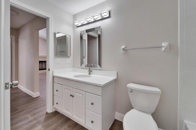 full bath with vanity, toilet, and wood finished floors