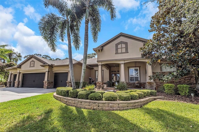 mediterranean / spanish home featuring a garage, concrete driveway, stone siding, stucco siding, and a front yard