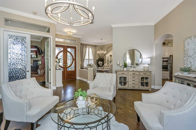 sitting room with an inviting chandelier, ornamental molding, arched walkways, and wood finished floors