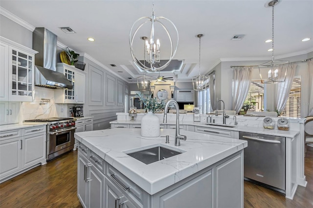 kitchen with stainless steel appliances, a sink, a center island with sink, and an inviting chandelier