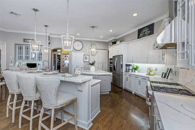 kitchen featuring stainless steel appliances, visible vents, ventilation hood, a center island, and dark wood-style floors