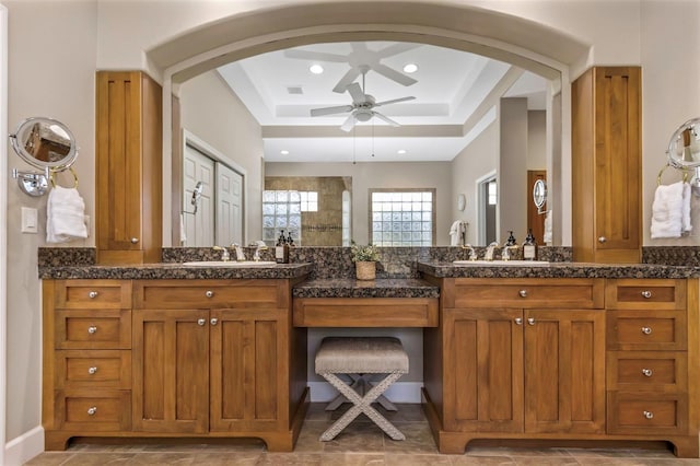 bathroom with recessed lighting, ceiling fan, vanity, and a tray ceiling