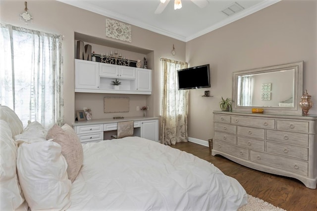 bedroom with visible vents, dark wood-style flooring, crown molding, multiple windows, and built in desk