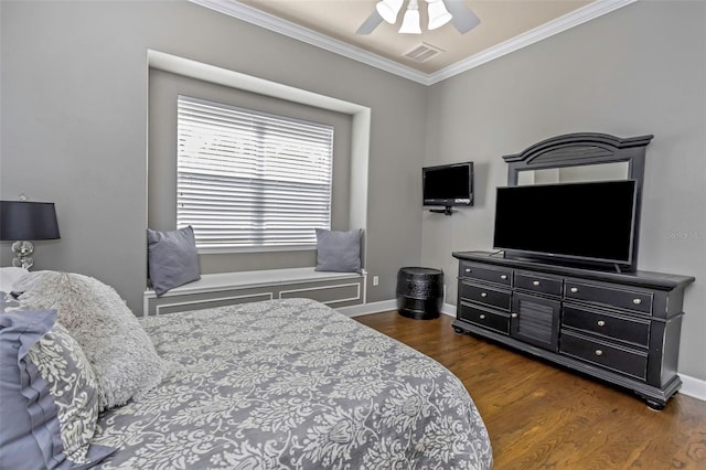 bedroom featuring ornamental molding, visible vents, baseboards, and wood finished floors