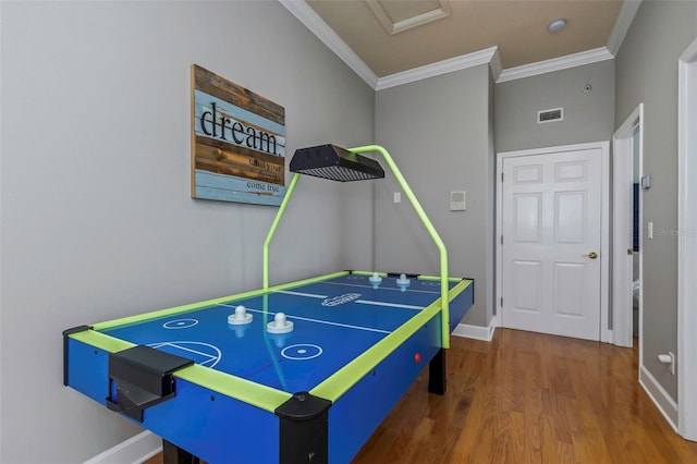 game room with ornamental molding, visible vents, baseboards, and wood finished floors