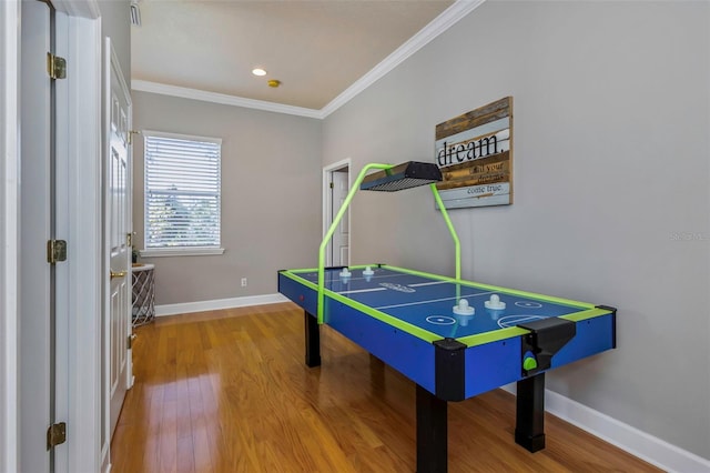 game room with crown molding, baseboards, and wood finished floors