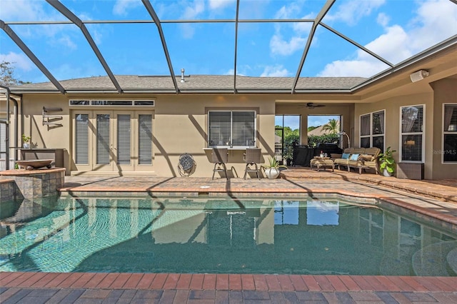 outdoor pool featuring a patio, glass enclosure, and a ceiling fan