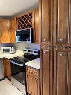 kitchen featuring stainless steel appliances and brown cabinetry