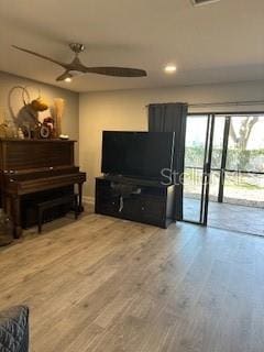 living room with a ceiling fan and wood finished floors