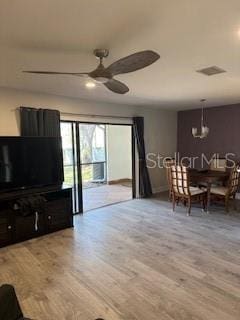 living room featuring baseboards, wood finished floors, visible vents, and a ceiling fan