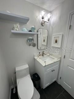 bathroom with toilet, tile patterned flooring, and vanity