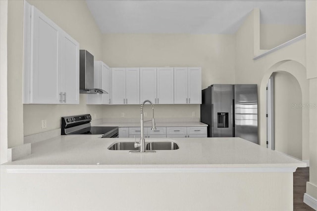 kitchen featuring wall chimney exhaust hood, appliances with stainless steel finishes, light countertops, and a sink