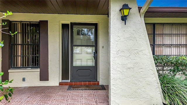 doorway to property featuring stucco siding