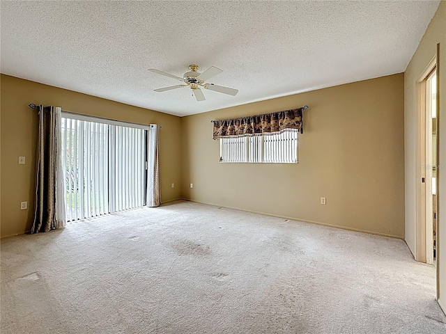 unfurnished room with ceiling fan, a textured ceiling, and light colored carpet