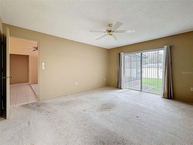 unfurnished room featuring carpet floors, ceiling fan, a textured ceiling, and tile patterned floors