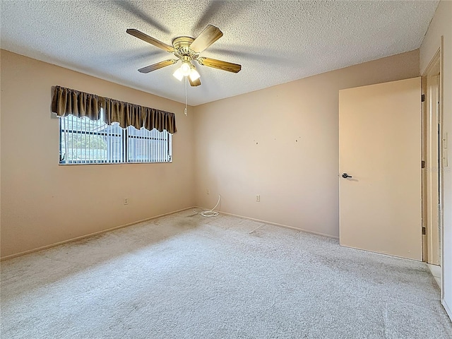 empty room with a ceiling fan, a textured ceiling, and carpet flooring