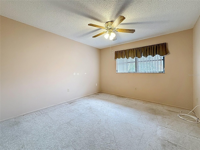 spare room featuring carpet flooring, ceiling fan, a textured ceiling, and baseboards