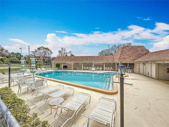 community pool featuring a patio and fence