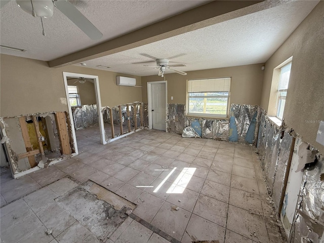 spare room featuring visible vents, ceiling fan, a textured ceiling, and a wall mounted AC