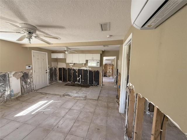 interior space with a ceiling fan, visible vents, and a wall mounted AC