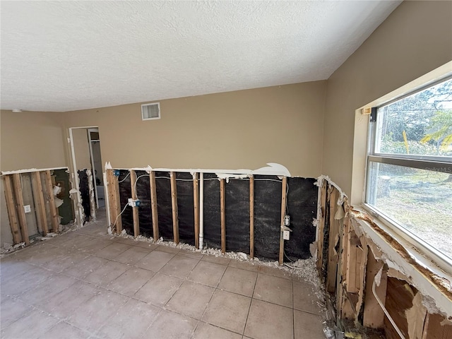 unfurnished room featuring visible vents and a textured ceiling