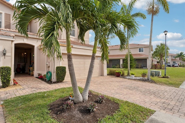 view of front of property with a front lawn, decorative driveway, a tile roof, and stucco siding