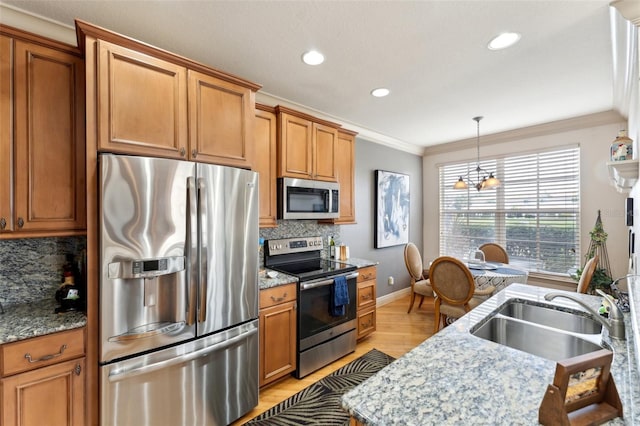 kitchen with crown molding, tasteful backsplash, appliances with stainless steel finishes, a sink, and baseboards