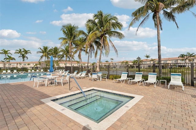 community pool with a community hot tub, a patio area, and fence