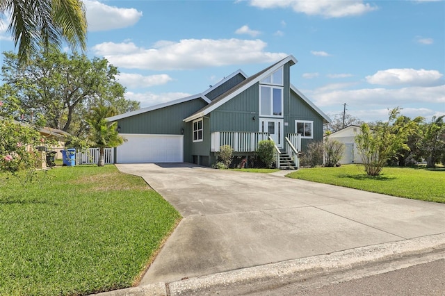 view of front of house featuring an attached garage, concrete driveway, and a front yard