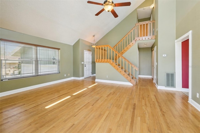 unfurnished living room with stairway, wood finished floors, visible vents, and baseboards