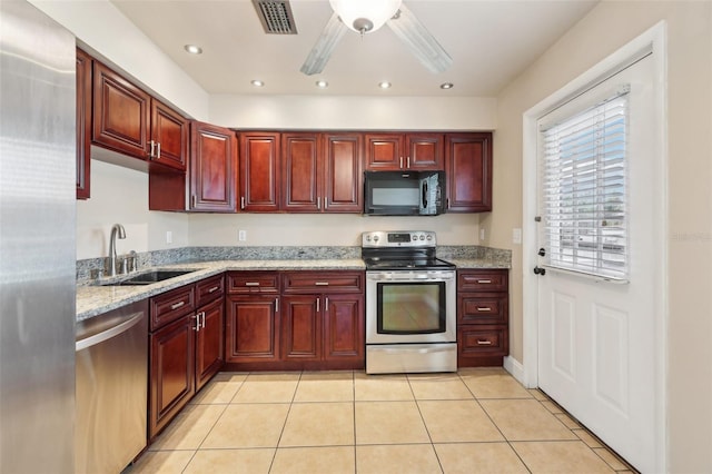 kitchen with stainless steel appliances, dark brown cabinets, and a sink