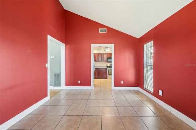 unfurnished room featuring light tile patterned floors, high vaulted ceiling, visible vents, and baseboards