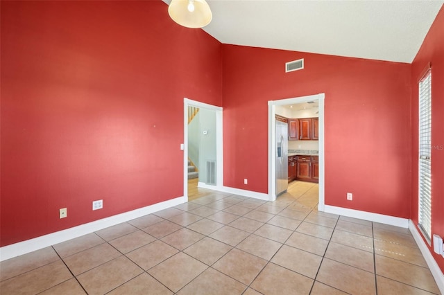 unfurnished room with visible vents, stairway, baseboards, and light tile patterned floors