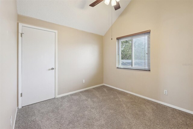 unfurnished room with a ceiling fan, carpet, lofted ceiling, and baseboards