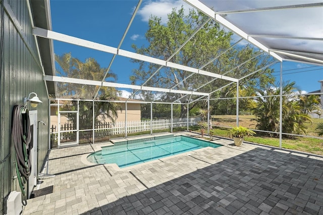 view of pool featuring glass enclosure, fence, a fenced in pool, and a patio