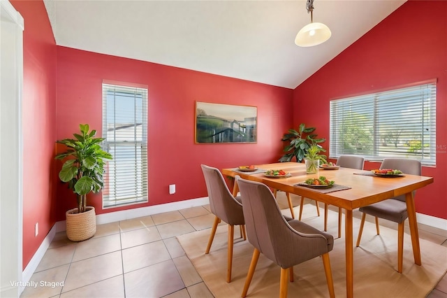 dining area featuring plenty of natural light, baseboards, vaulted ceiling, and light tile patterned flooring