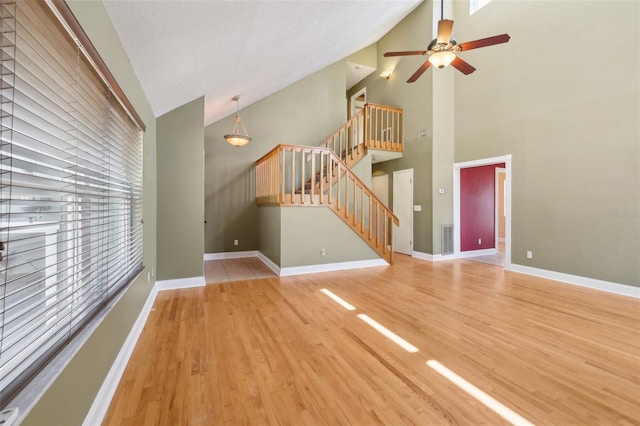 unfurnished living room with light wood finished floors, baseboards, stairway, and visible vents