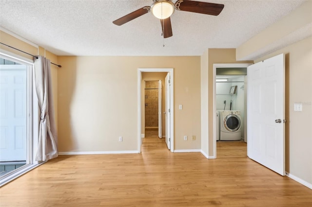 unfurnished bedroom featuring light wood-style floors, washing machine and dryer, baseboards, and a textured ceiling