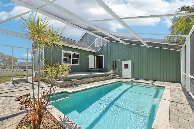 view of pool featuring glass enclosure, a fenced in pool, and a patio