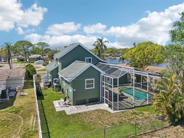 rear view of property with a yard, a patio, a lanai, a fenced backyard, and an outdoor pool