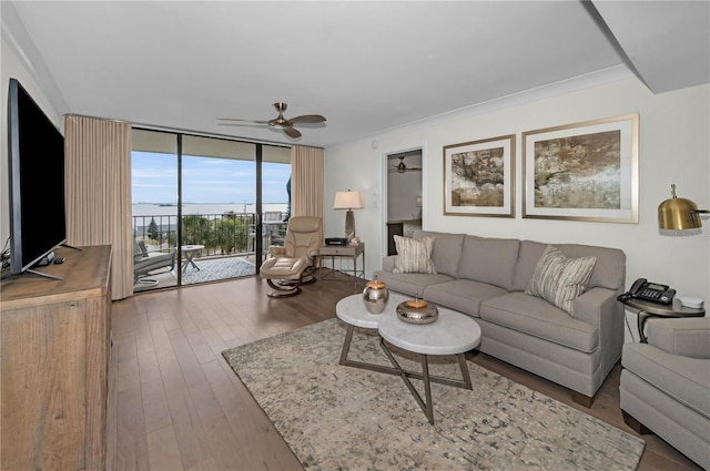 living area featuring a wall of windows, wood finished floors, and a ceiling fan