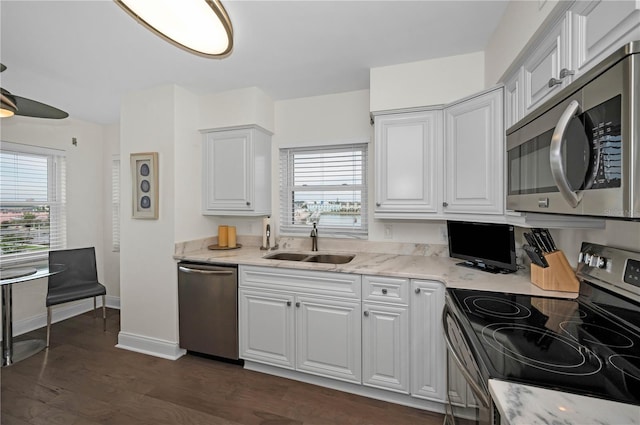 kitchen with white cabinetry, appliances with stainless steel finishes, dark wood-style flooring, and a sink