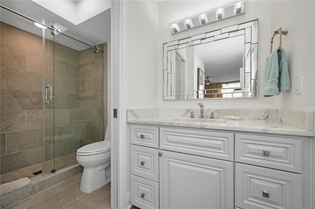 full bathroom with vanity, a shower stall, and toilet