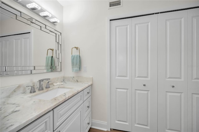 bathroom featuring baseboards, visible vents, a closet, and vanity