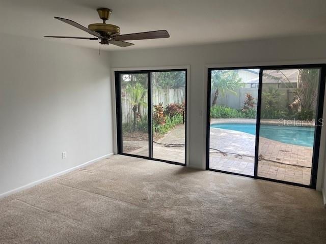 unfurnished room featuring carpet flooring, a ceiling fan, and baseboards