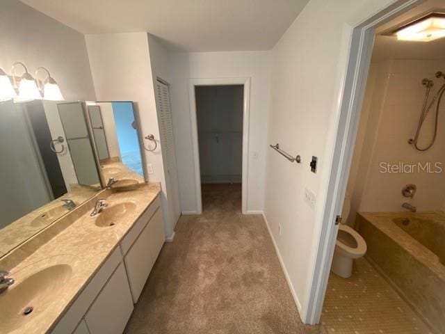 bathroom featuring double vanity, a sink, toilet, and baseboards