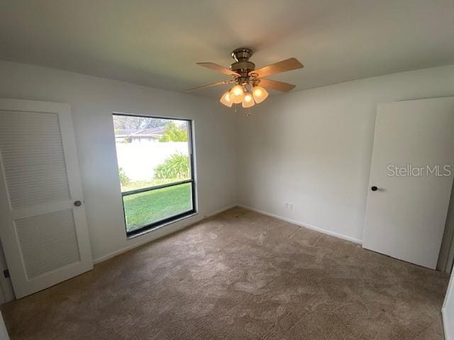 unfurnished bedroom featuring baseboards, a ceiling fan, and carpet flooring