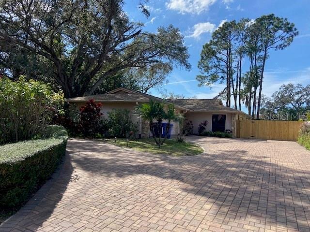 ranch-style house featuring fence and decorative driveway