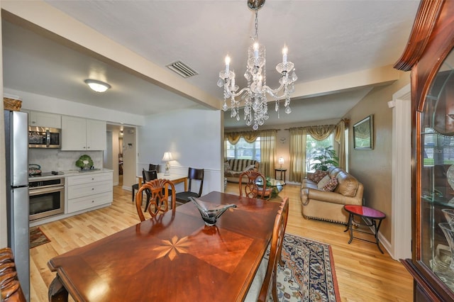 dining room with visible vents, baseboards, light wood-style flooring, beamed ceiling, and a chandelier