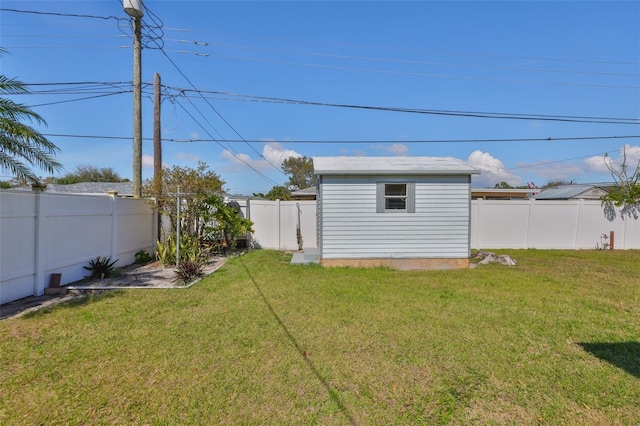 view of yard featuring an outbuilding, a shed, and a fenced backyard